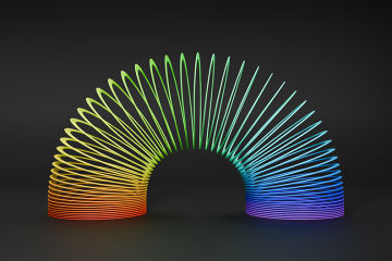 Plastic multicoloured slinky toy on a black background