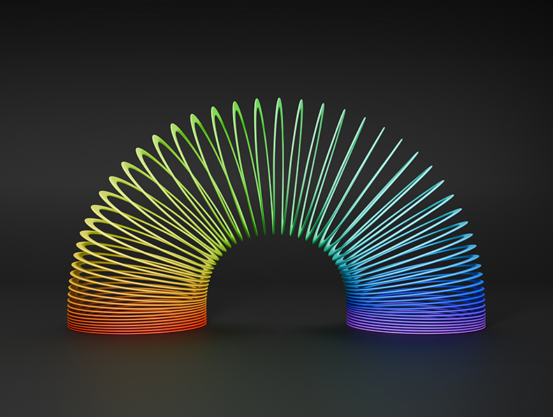 Plastic multicoloured slinky toy on a black background